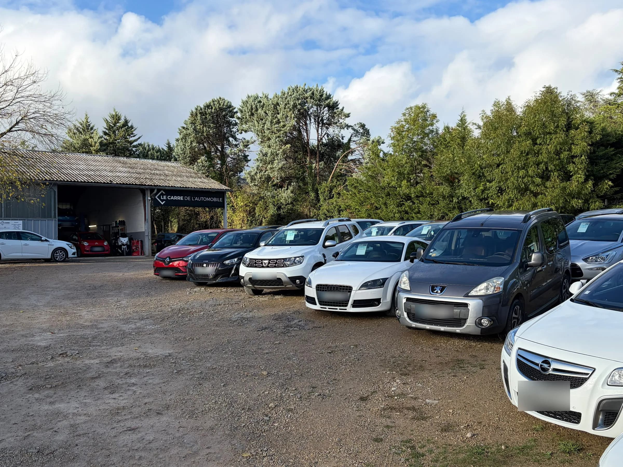Le parking du garage, les voitures en vente alignées devant le hangar